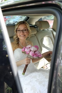 Svatební portrét nevěsty se svatební kyticí v autě
