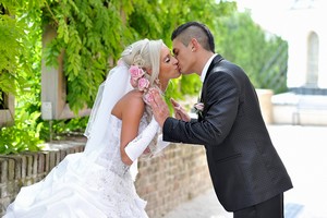 svatební fotografie portrét nevěsty a ženicha novomanželský polibek v parku