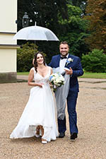 Šťastní novomanželé a ženich s deštníkem u zámku v Kostelci nad Orlicí